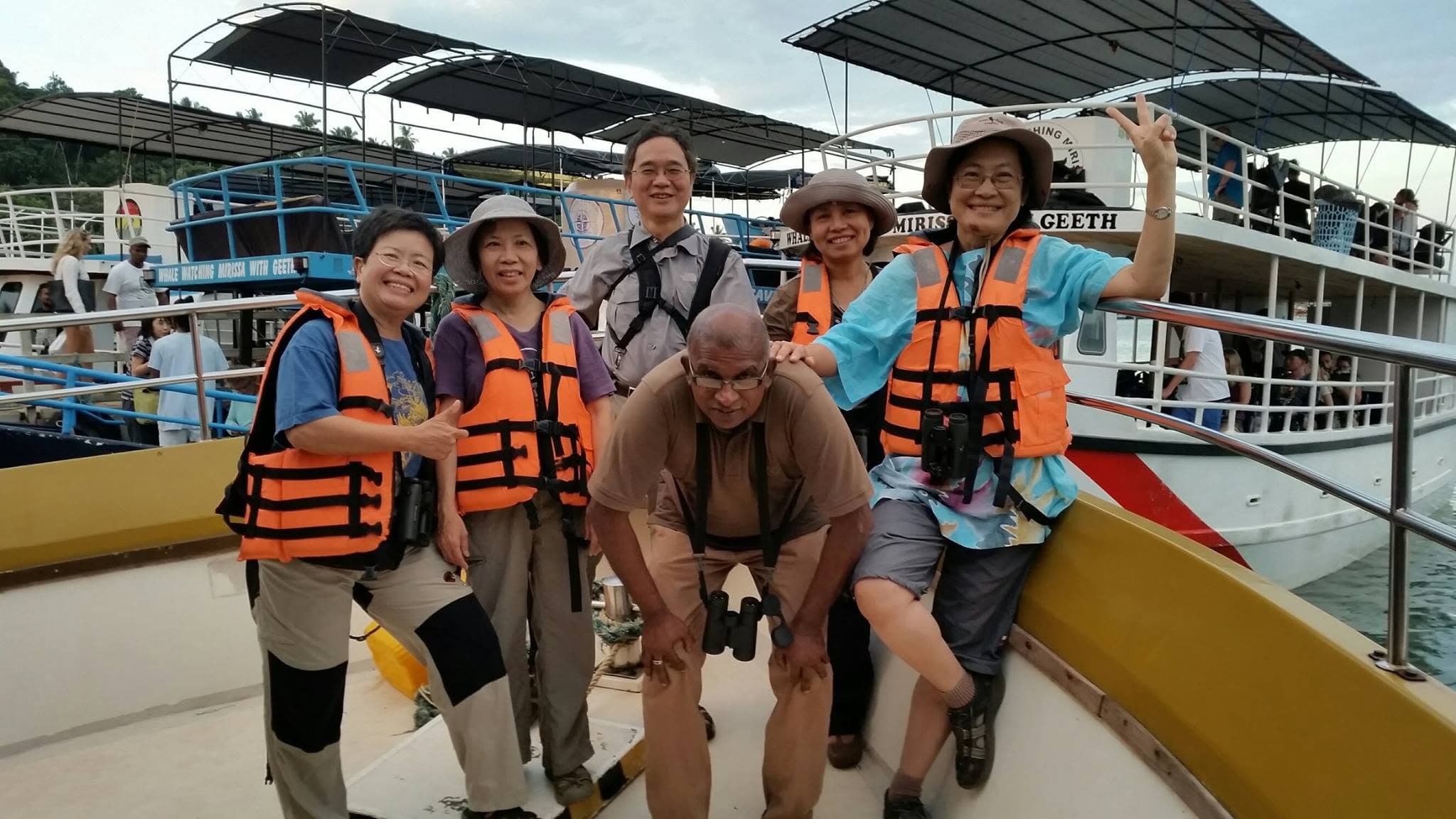 A guide with a group of guests aboard a boat during a whale-watching excursion at Mirissa